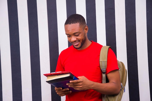 Giovane uomo africano bello che studia il suo libro