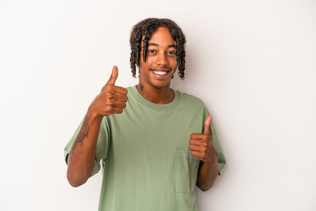 Giovane uomo afroamericano isolato su sfondo bianco alzando entrambi i pollici, sorridente e fiducioso.