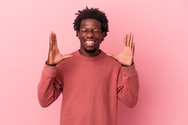 Giovane uomo afroamericano isolato su sfondo rosa ridendo gioioso molto. Concetto di felicità.