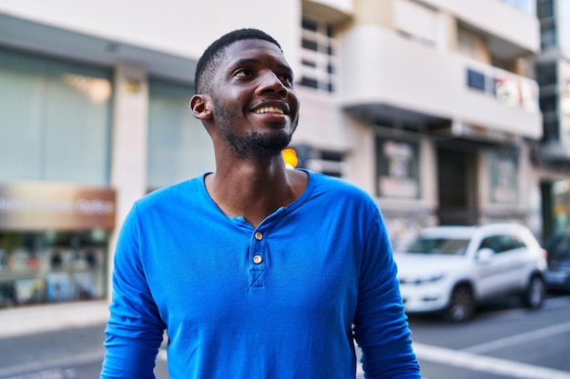 Giovane uomo afroamericano sorridente fiducioso in piedi in strada