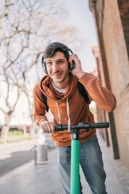 Giovane uomo alla guida di scooter elettrico.