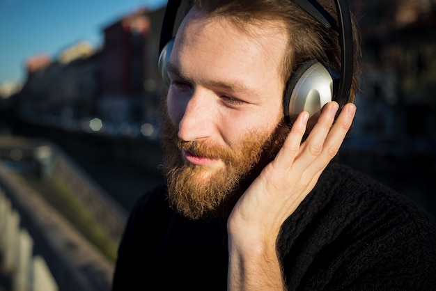 giovane uomo alla moda con la barba ascoltando musica
