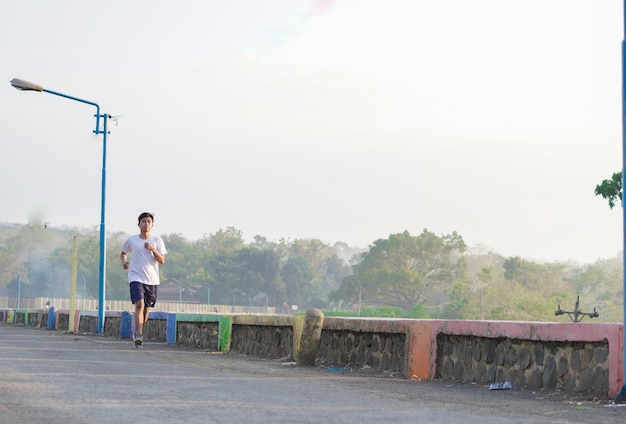 Giovane uomo asiatico che fa jogging al mattino