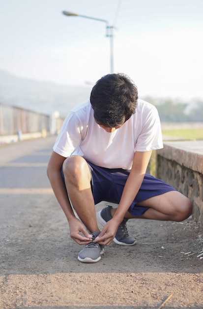 Giovane uomo asiatico che fa stretching prima di fare jogging al mattino