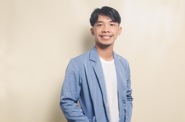 Giovane uomo asiatico che indossa la tuta del college sorridente su sfondo isolato
