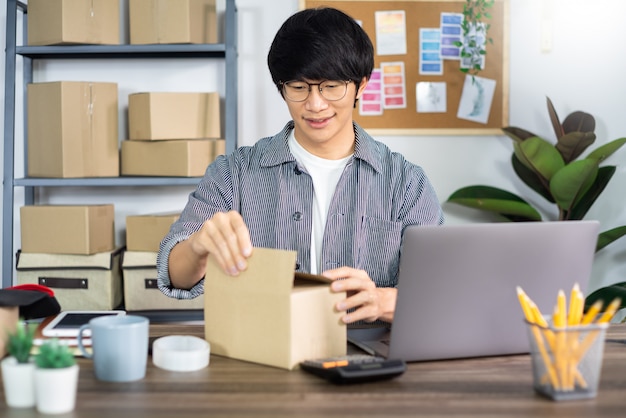 Giovane uomo asiatico che lavora all'ufficio di servizio di distribuzione