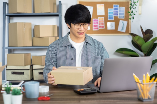 Giovane uomo asiatico che lavora all'ufficio di servizio di distribuzione