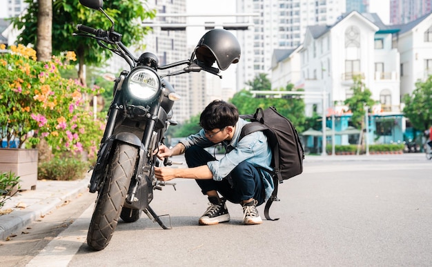 Giovane uomo asiatico che ripara moto