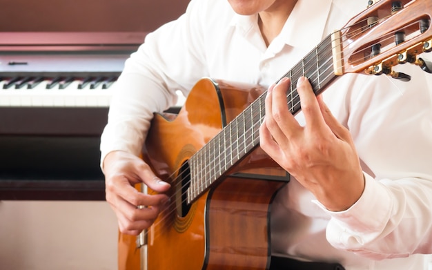 Giovane uomo asiatico che suona la chitarra