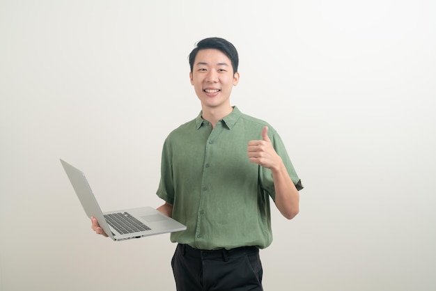 Giovane uomo asiatico con laptop a portata di mano