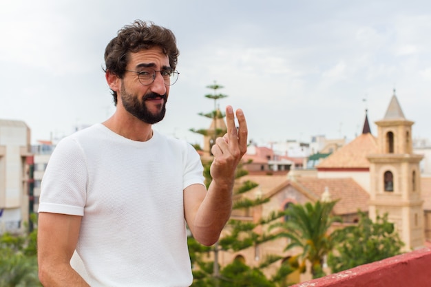 Giovane uomo barbuto che fuma una sigaretta