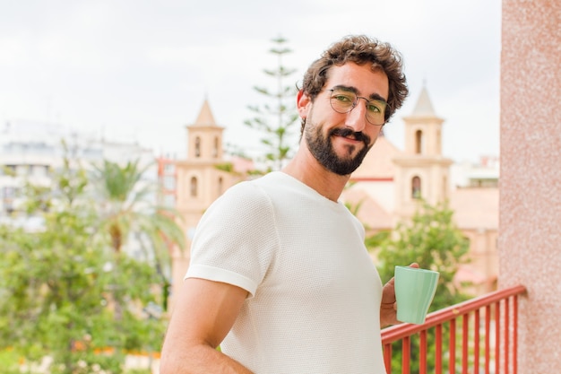 Giovane uomo barbuto con un caffè