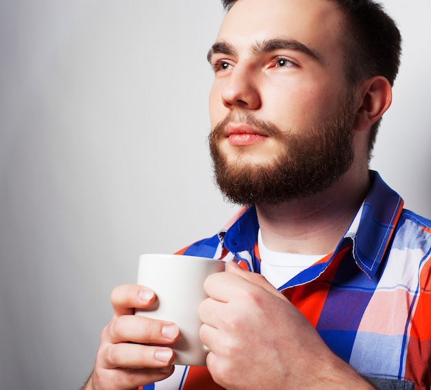 Giovane uomo barbuto con una tazza di caffè