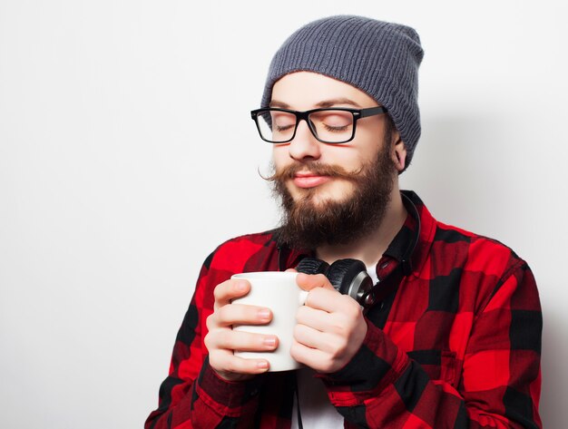 Giovane uomo barbuto con una tazza di caffè