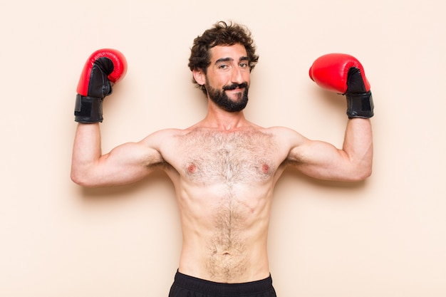 Giovane uomo barbuto freddo con guantoni da boxe e concetto di fitness di combattimento