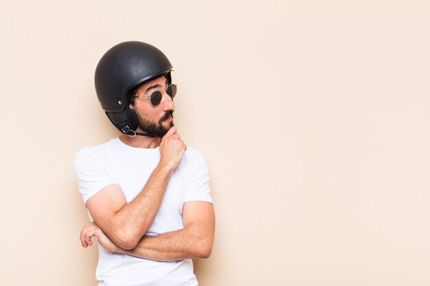 Giovane uomo barbuto freddo con un pensiero del casco