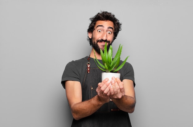 Giovane uomo barbuto holding cactus