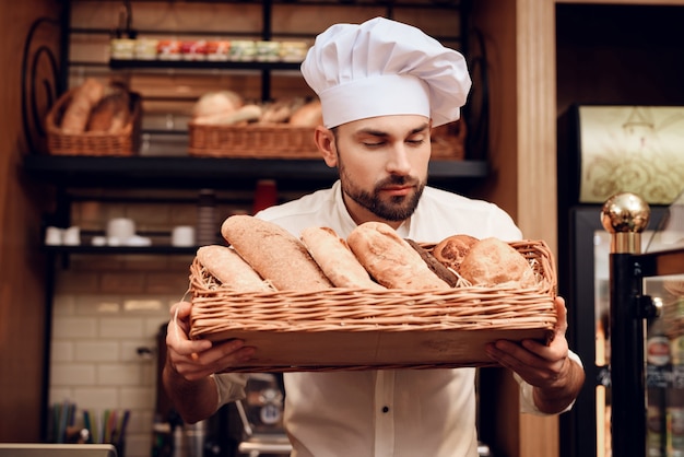 Giovane uomo barbuto in cappuccio bianco che sta in forno