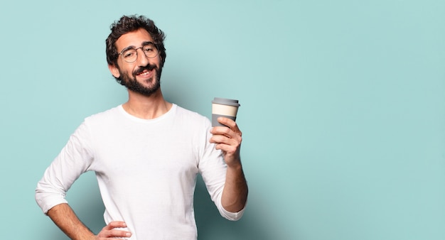 Giovane uomo barbuto pazzo con un caffè da asporto