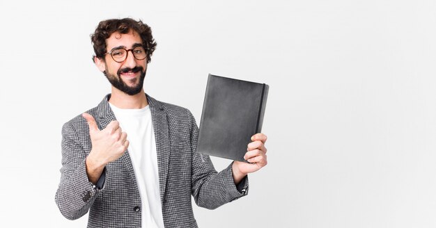 Giovane uomo barbuto pazzo con un taccuino