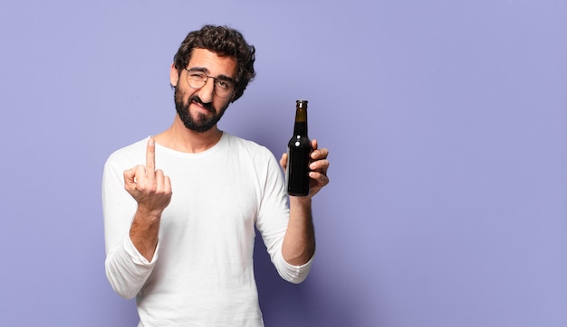 Giovane uomo barbuto pazzo con una birra