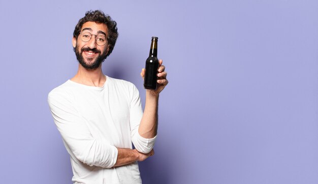 Giovane uomo barbuto pazzo con una birra