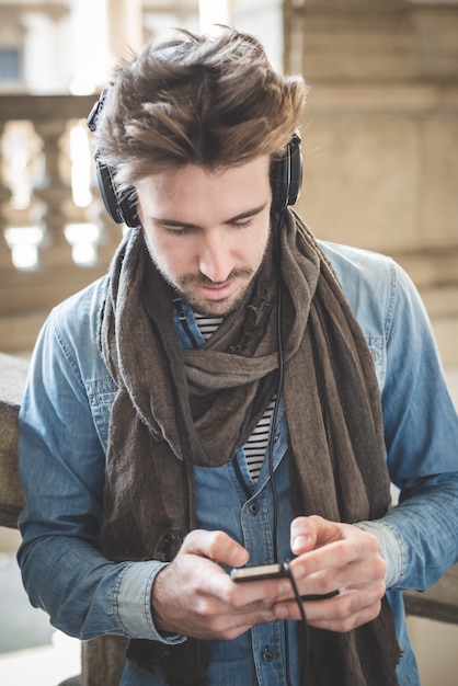 giovane uomo bello ascoltare musica con le cuffie