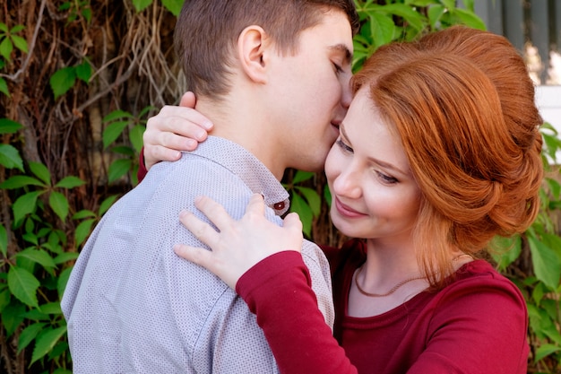 Giovane uomo bello che abbraccia la donna abbastanza giovane di redhead