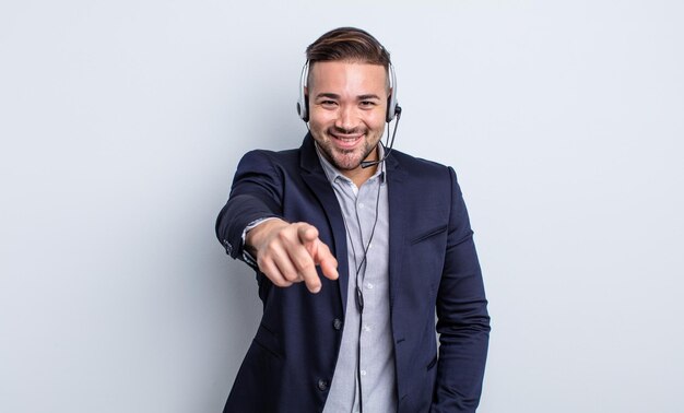 Giovane uomo bello che punta alla telecamera scegliendo te. concetto di telemarketer