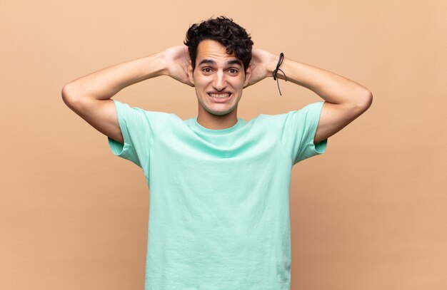 Giovane uomo bello che sembra felice, spensierato, amichevole e rilassato godersi la vita e il successo, con un atteggiamento positivo