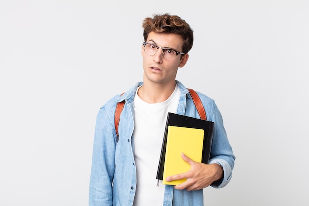 Giovane uomo bello che si sente perplesso e confuso. concetto di studente universitario