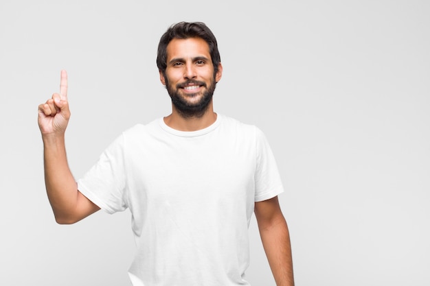 Giovane uomo bello che sorride allegramente e felicemente