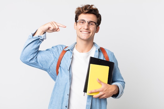 Giovane uomo bello che sorride con sicurezza indicando il proprio ampio sorriso. concetto di studente universitario