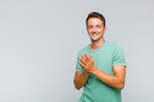 Giovane uomo bello che sorride e sembra amichevole, mostrando il numero due