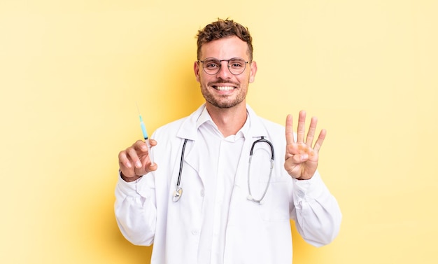 Giovane uomo bello che sorride e sembra amichevole, mostrando il numero quattro. concetto di siringa del medico