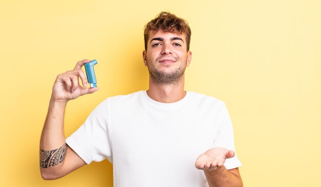 Giovane uomo bello che sorride felicemente con amichevole e offrendo e mostrando un concetto. concetto di asma