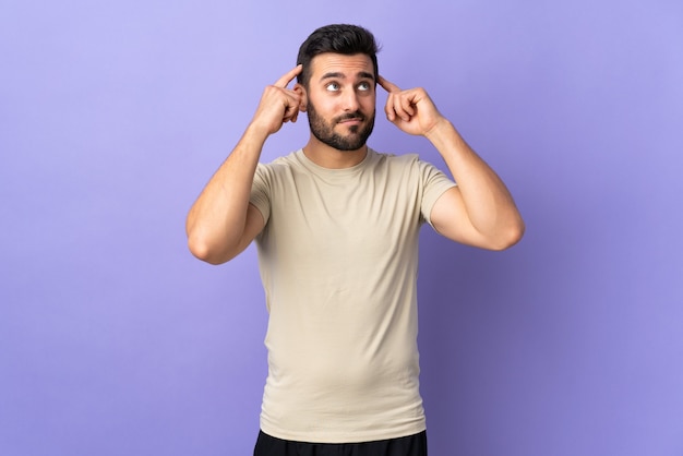 Giovane uomo bello con la barba che ha dubbi e pensiero