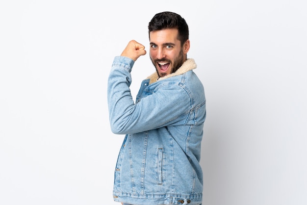 Giovane uomo bello con la barba isolata su bianco facendo un forte gesto