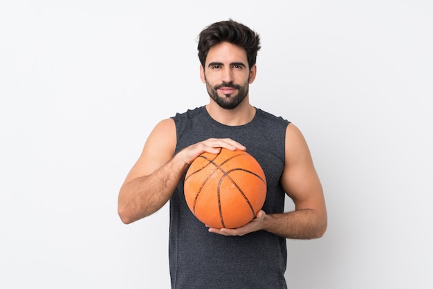 Giovane uomo bello con la barba sopra la parete bianca isolata giocando a basket