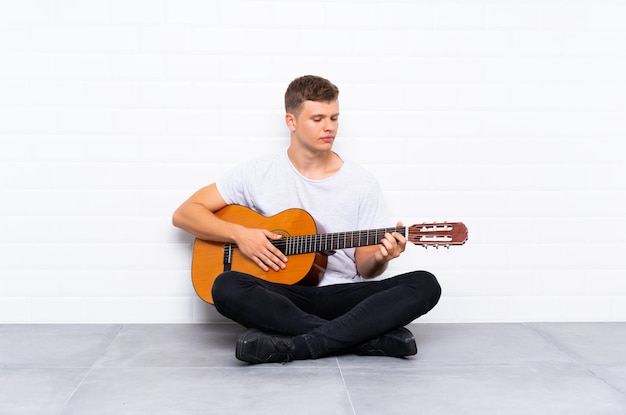 Giovane uomo bello con la chitarra