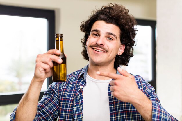 Giovane uomo bello con una birra a casa all'interno di casa