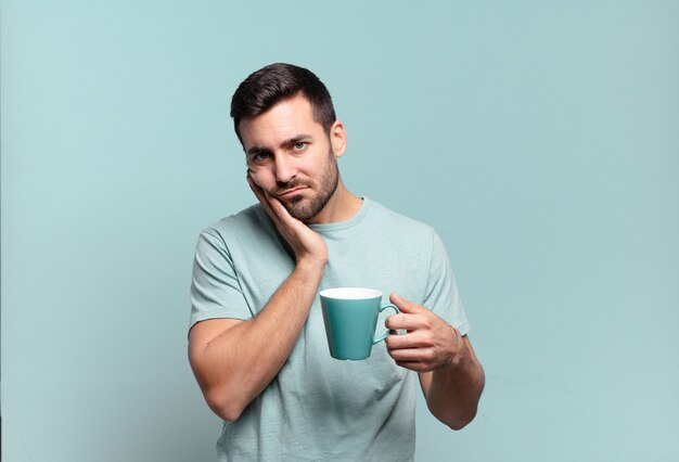 giovane uomo bello con una tazza di caffè. concetto di colazione