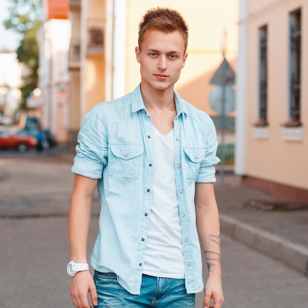 Giovane uomo bello in una camicia di jeans e jeans