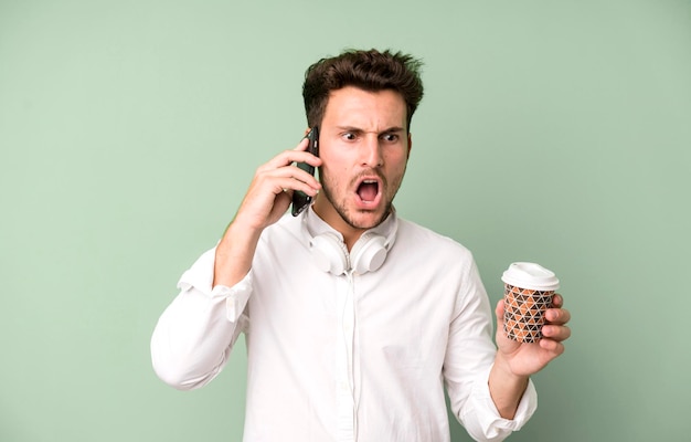 Giovane uomo bello isolato usando il suo telefono