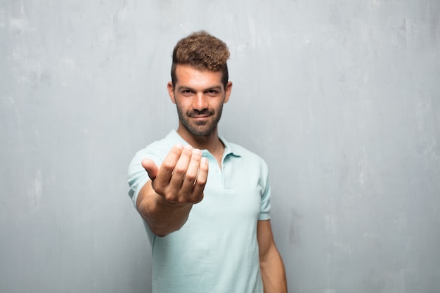 Giovane uomo bello sorridente con uno sguardo fiero, soddisfatto e felice, accettando una sfida