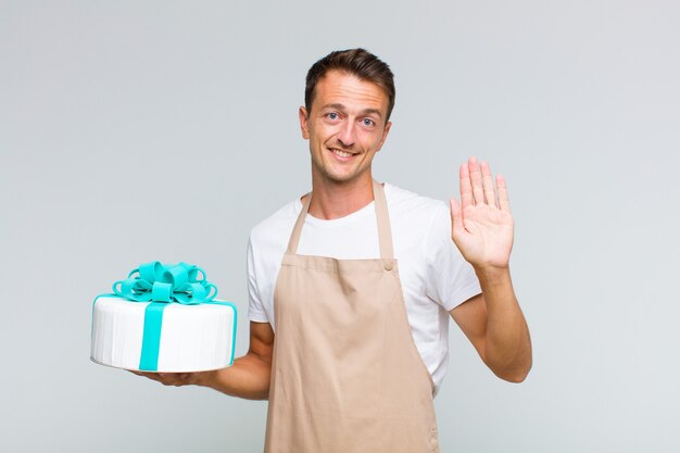 Giovane uomo bello sorridente e guardando amichevole, mostrando il numero uno o il primo con la mano in avanti, il conto alla rovescia