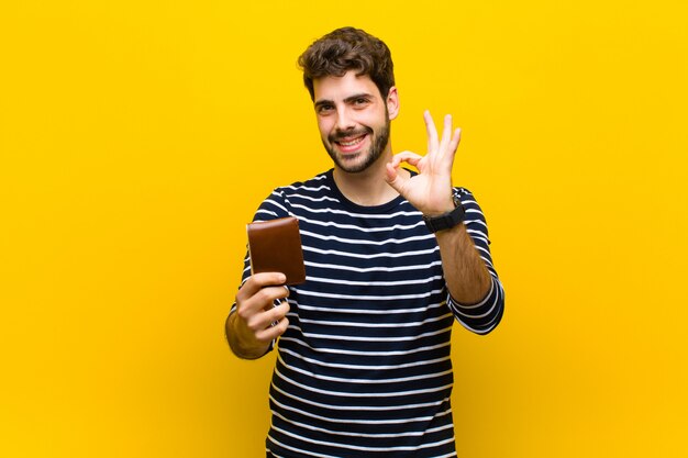 Giovane uomo bello su sfondo arancione