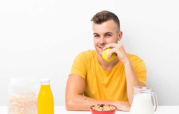 Giovane uomo biondo che mangia prima colazione