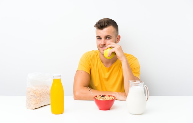 Giovane uomo biondo che mangia prima colazione