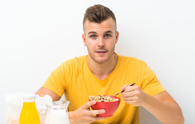 Giovane uomo biondo che mangia prima colazione